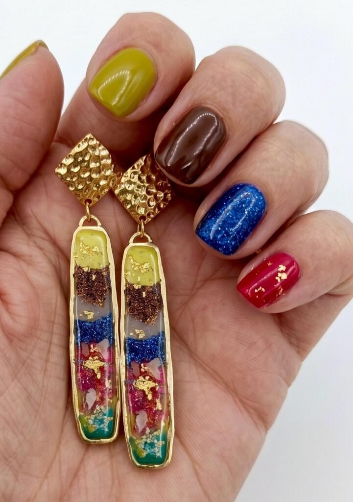 Pendientes artesanales hechos en resinas, pan de oro y otros elementos decorativos y acero inoxidable